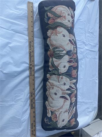 needlepoint pillow with a design of rabbits.