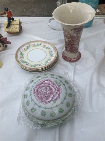Variety of decorative porcelain items, including a stack of plates and a tall
