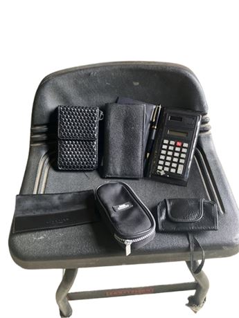 various leather or faux-leather organizers, wallets, and a calculator