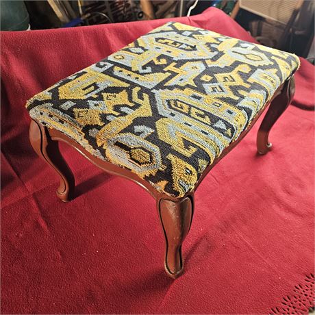 Upholstered footstool with cabriole legs. Made by United Wood Products Co.