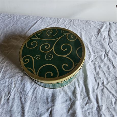 Decorative tin box with a green and gold filigree pattern.