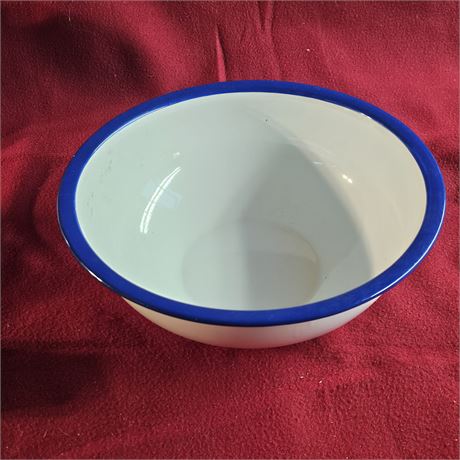 White enamel bowl with a blue rim. Enamelware