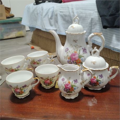 Porcelain tea set. It includes a teapot, a sugar bowl, a creamer, and multiple