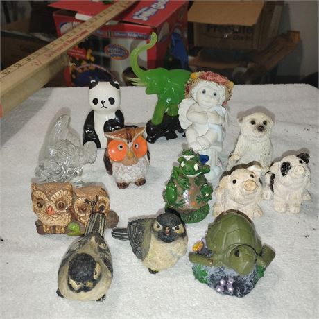 Figurines include a panda, several owls, a turtle, a pig, a white dog, a small d
