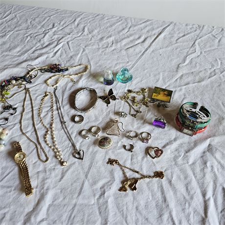 Assorted jewelry, including necklaces, bracelets, rings, and watches.