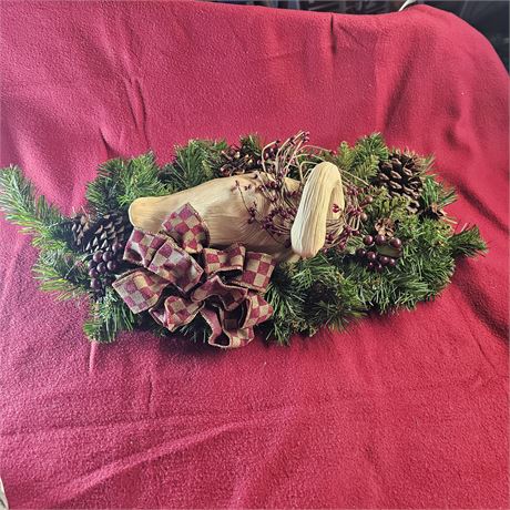 Decorated holiday arrangement, likely a Yule log centerpiece