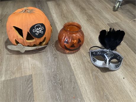 Halloween decorations featuring two pumpkins and a masquerade mask.