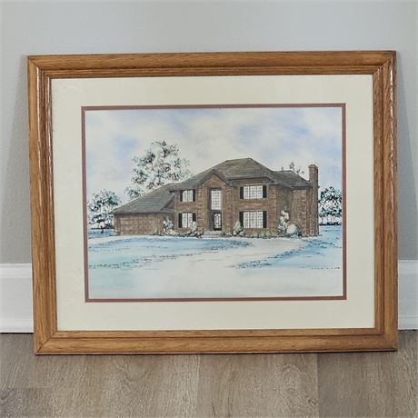 Framed picture of a large, two-story brick house