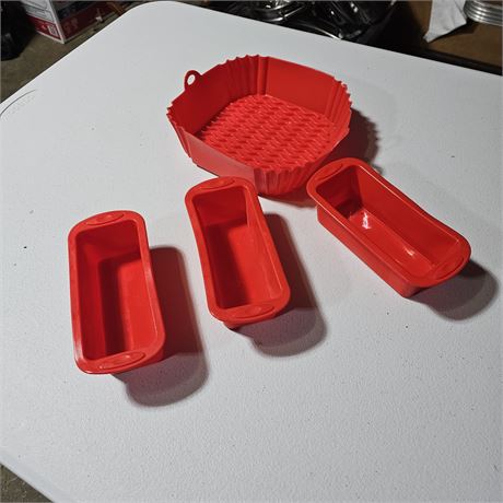 Red silicone loaf pans and a larger square silicone pan