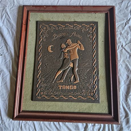 Vintage-style repoussé artwork depicting two people dancing the tango.