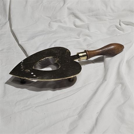 Baldwin Brass heart-shaped trivet with a wooden handle.
