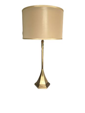 Mid-century modern brass table lamp with a beige fabric shade.