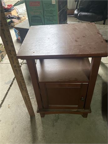 Small,  side table with an open shelf and a cabinet door.