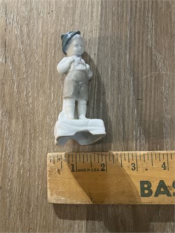 vintage porcelain figurine of a Bavarian boy, likely produced by Dresden.