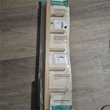 Over-door hanging rack made of hardwood with pegs.