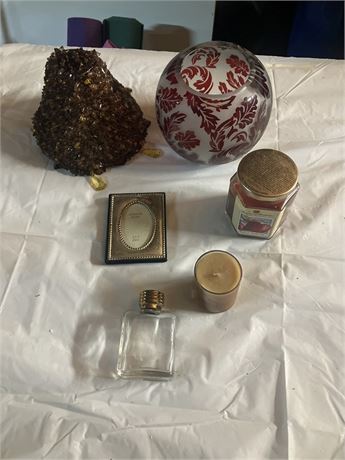 collection of decorative objects, including two candles, a small picture frame,