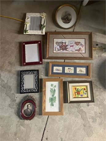 Collection of assorted picture frames and framed art pieces.