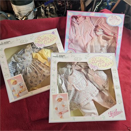 Three boxes of doll clothes