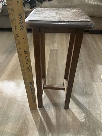 Small, rustic wooden plant stand or accent table.