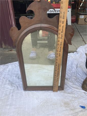 vintage wood-framed mirror with an arched top