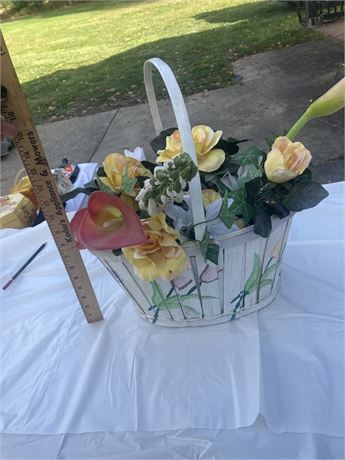 White basket with a handle, filled with artificial flowers